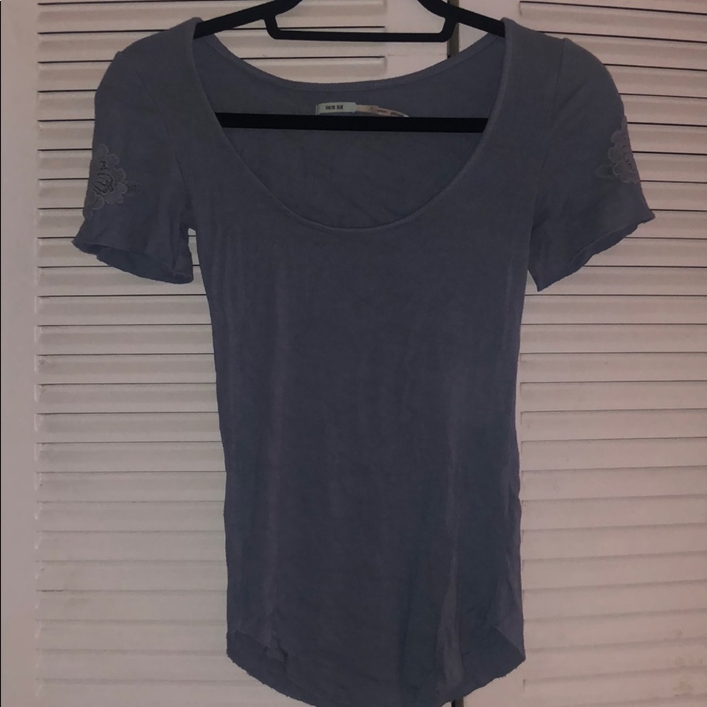 Light blue scoop neck shirt with sleeve flower